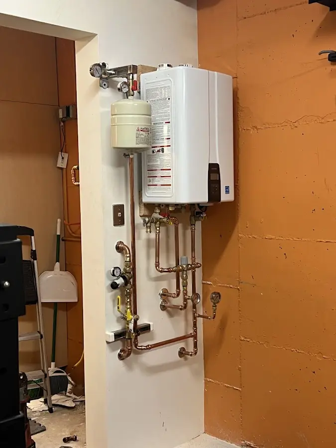 Plumbing technician inspecting water heater connections in Kenedy